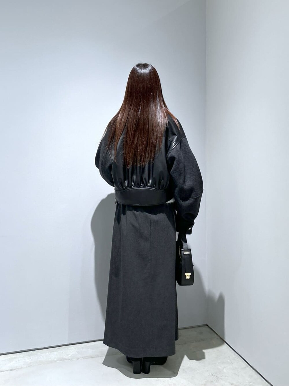 ブラック系のブルゾン、ホワイト系のニット/セーター、グレー系のスカートを着用したレディースの冬コーディネートの5枚目の写真