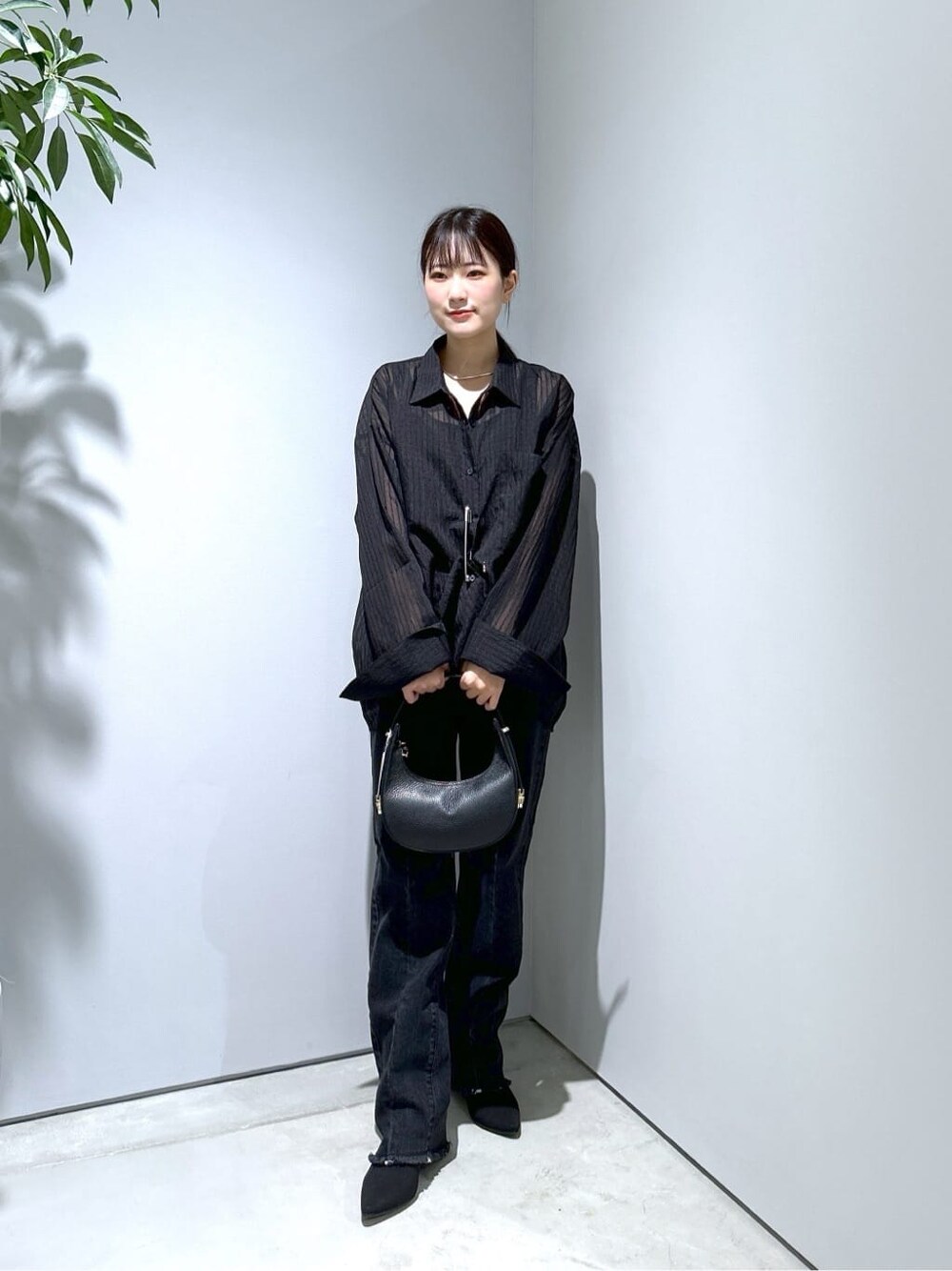 ブラック系のシャツ/ブラウス、グレー系のデニムパンツ、ブラック系のショルダーバッグを着用したレディースの秋コーディネートの3枚目の写真