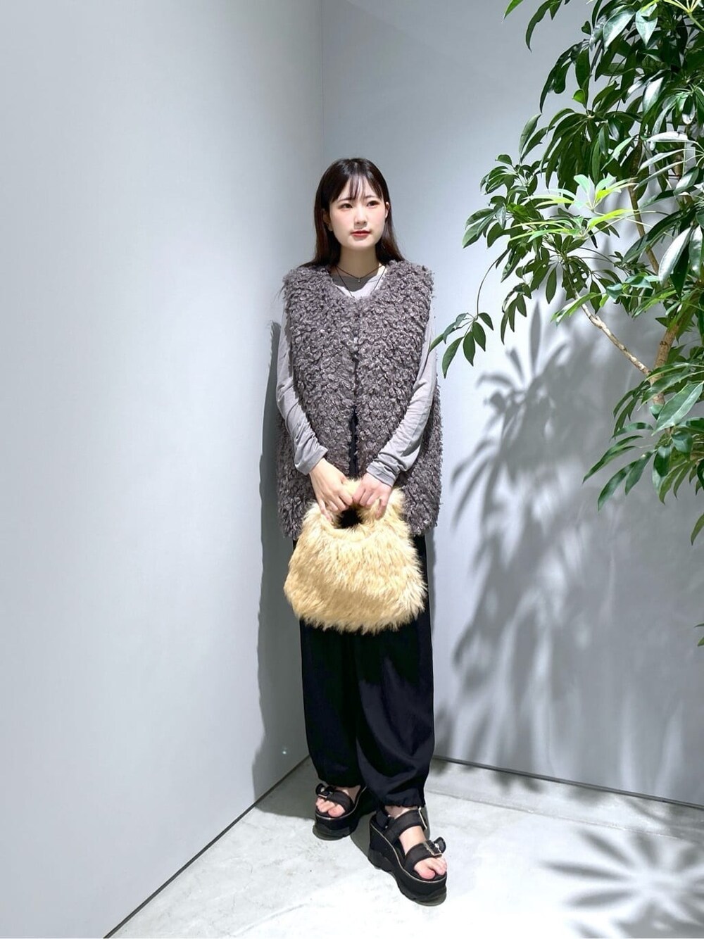 グレー系のTシャツ/カットソー、ブラック系のその他パンツ、ベージュ系のハンドバッグを着用したレディースの秋コーディネートの2枚目の写真