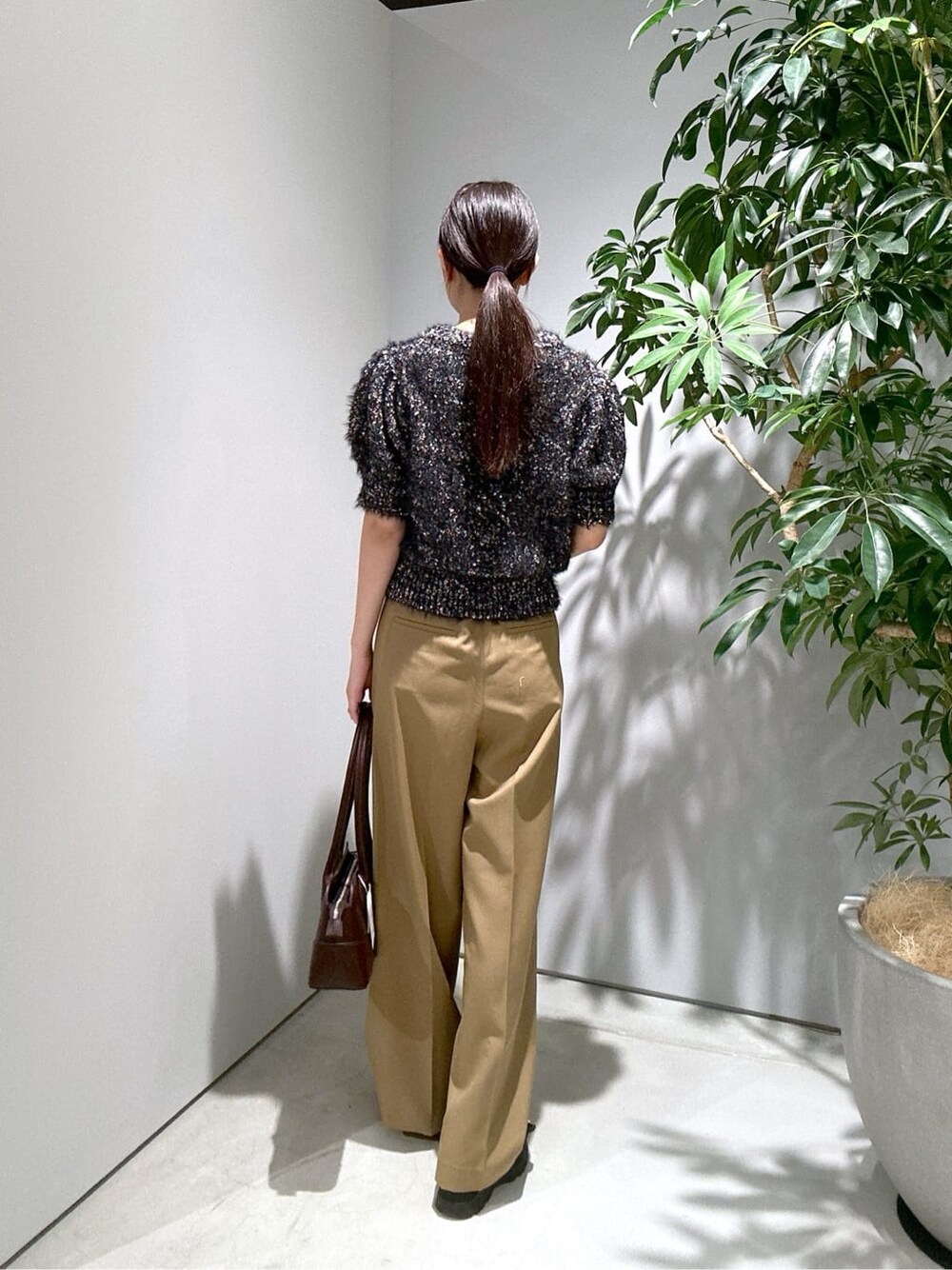 ブラック系のニット/セーター、イエロー系のその他パンツ、ブラウン系のショルダーバッグを着用したレディースの秋コーディネートの5枚目の写真