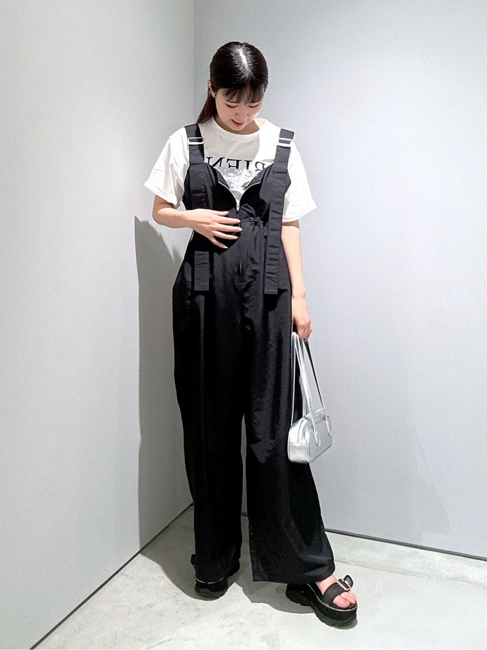 ホワイト系のTシャツ/カットソー、ブラック系のサロペット/オーバーオール、シルバー系のハンドバッグを着用したレディースの夏コーディネートの5枚目の写真