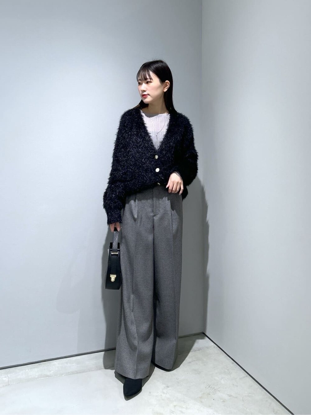 ブラック系のカーディガン/ボレロ、ブラック系のその他パンツ、ブラック系のショルダーバッグを着用したレディースの冬コーディネートの2枚目の写真