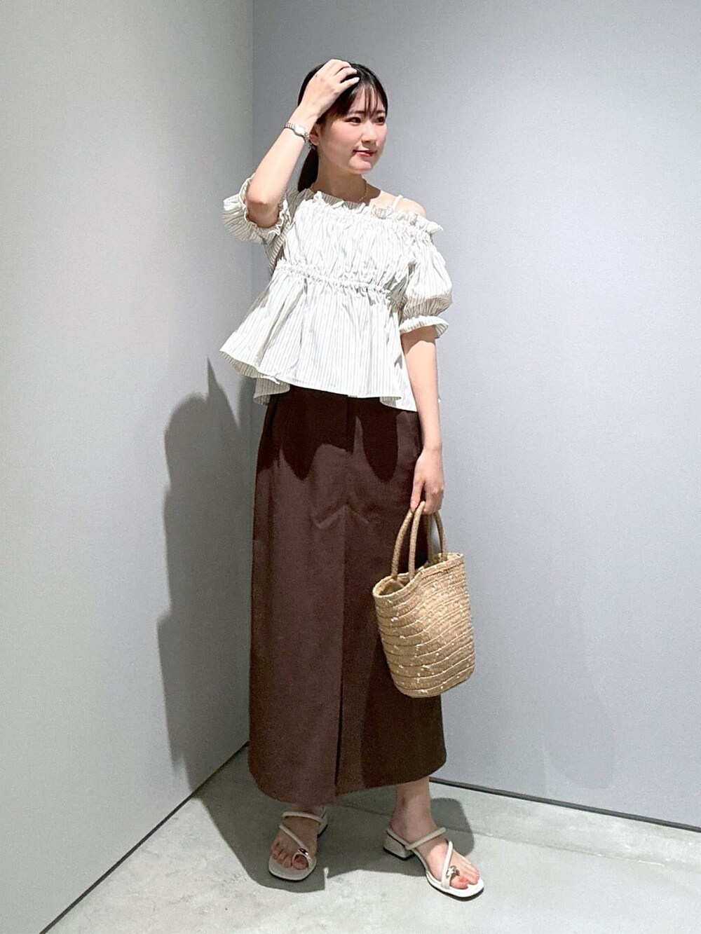 ベージュ系のシャツ/ブラウス、ブラウン系のスカート、ホワイト系のサンダルを着用したレディースの夏コーディネートの3枚目の写真