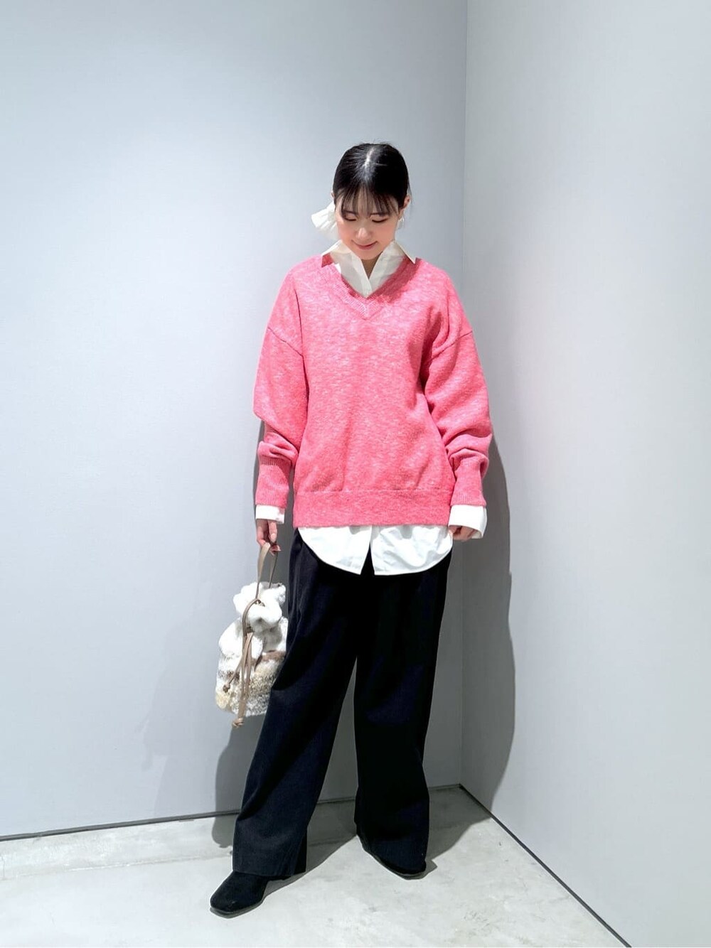 ピンク系のニット/セーター、ホワイト系のシャツ/ブラウス、ブラック系のその他パンツを着用したレディースの冬コーディネートの4枚目の写真