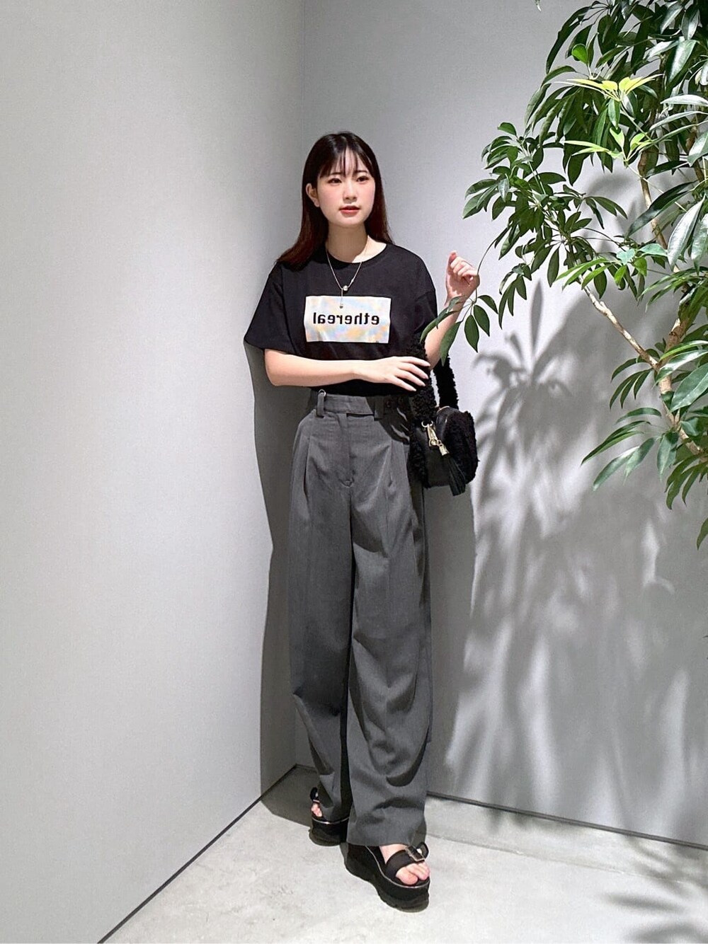 ブラック系のTシャツ/カットソー、グレー系のその他パンツ、ブラック系のハンドバッグを着用したレディースの夏コーディネートの2枚目の写真