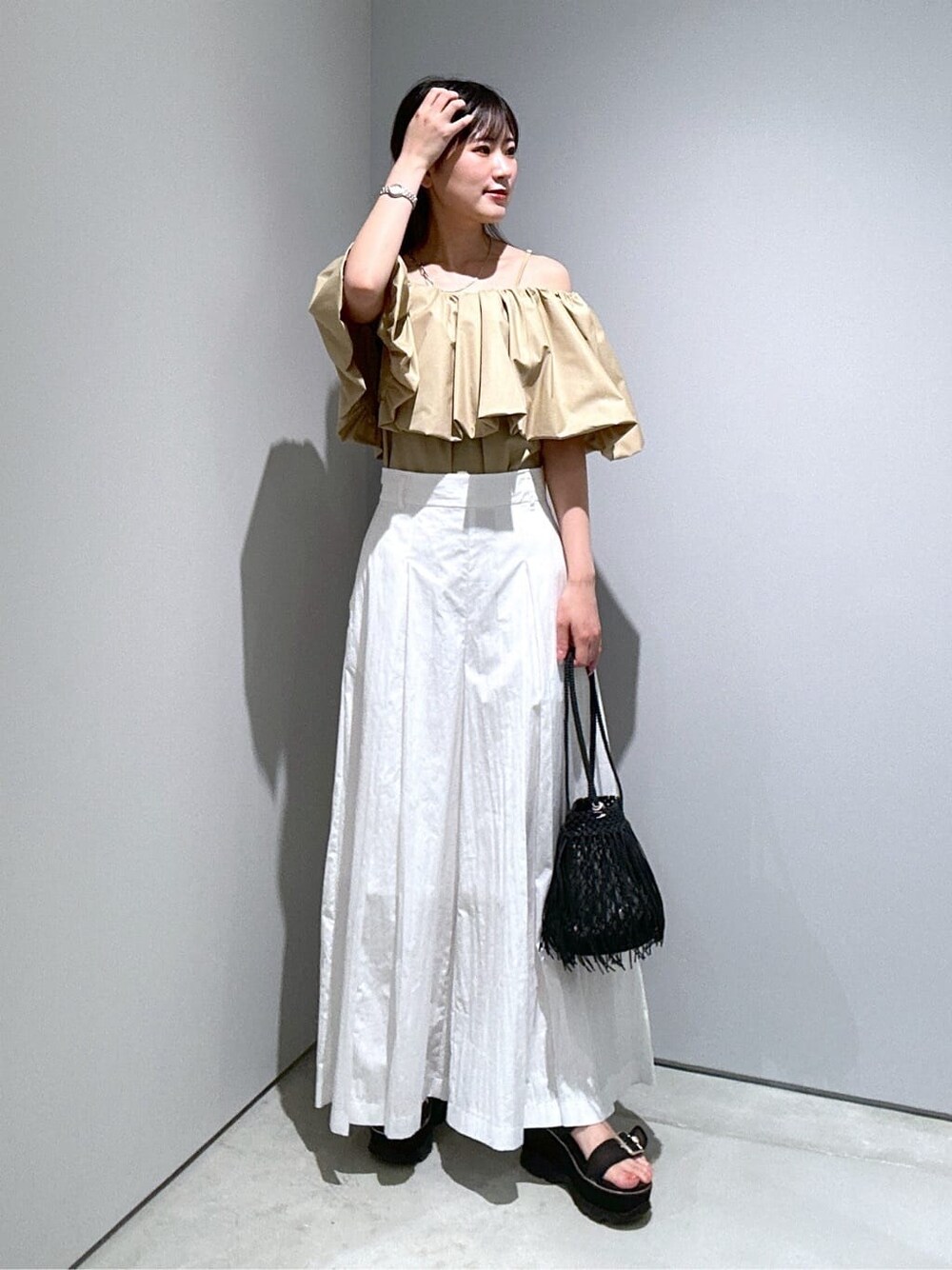 ベージュ系のシャツ/ブラウス、ホワイト系のその他パンツ、ブラック系のハンドバッグを着用したレディースの夏コーディネートの3枚目の写真