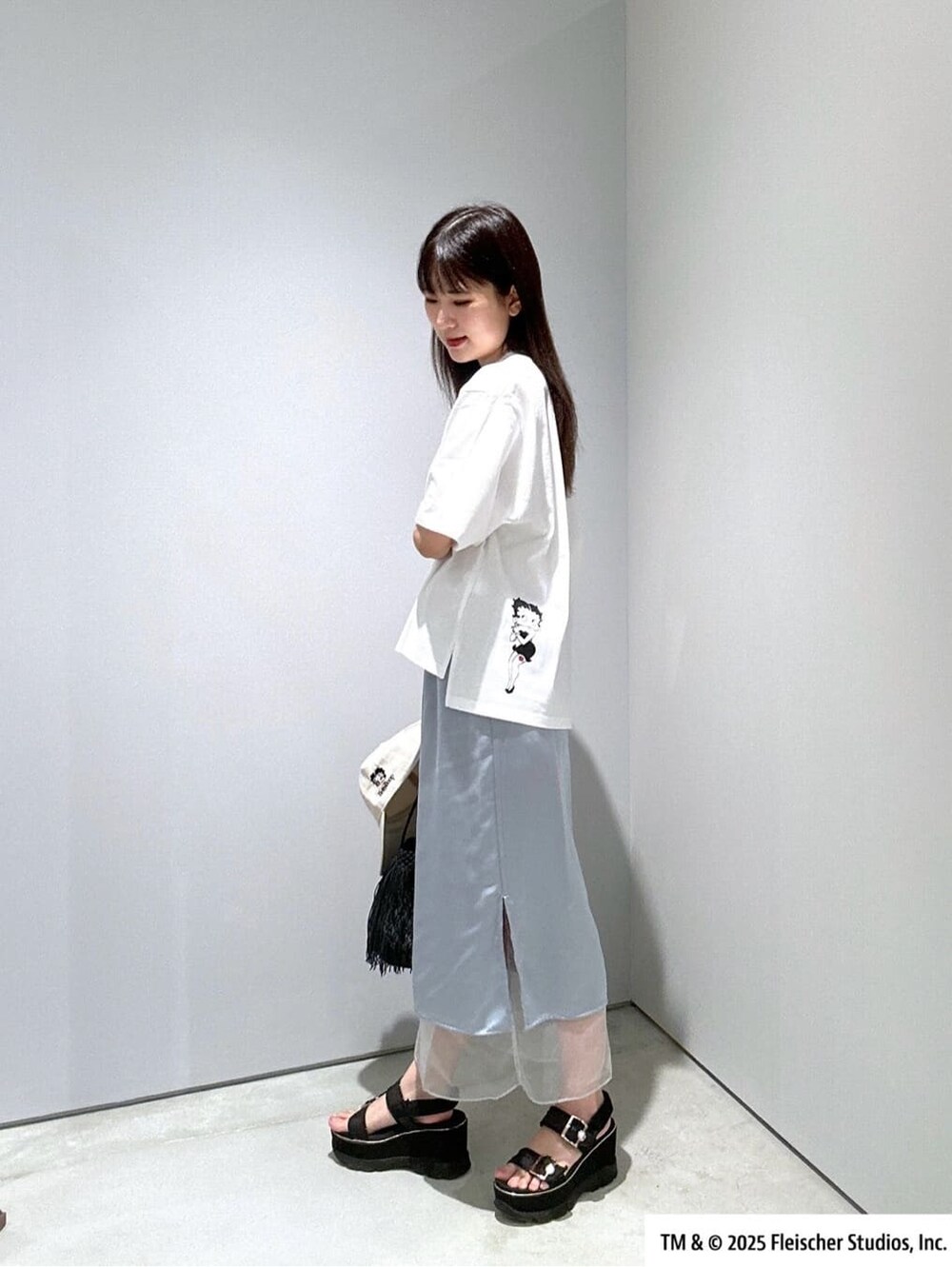 ホワイト系のTシャツ/カットソー、ブルー系のスカート、ブラック系のハンドバッグを着用したレディースの夏コーディネートの5枚目の写真