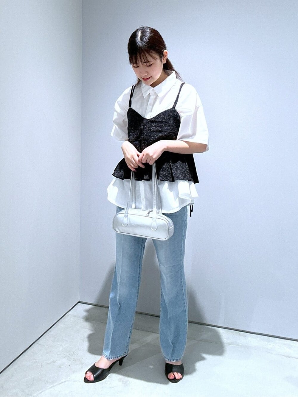 ホワイト系のシャツ/ブラウス、ブルー系のデニムパンツ、シルバー系のハンドバッグを着用したレディースの夏コーディネートの4枚目の写真
