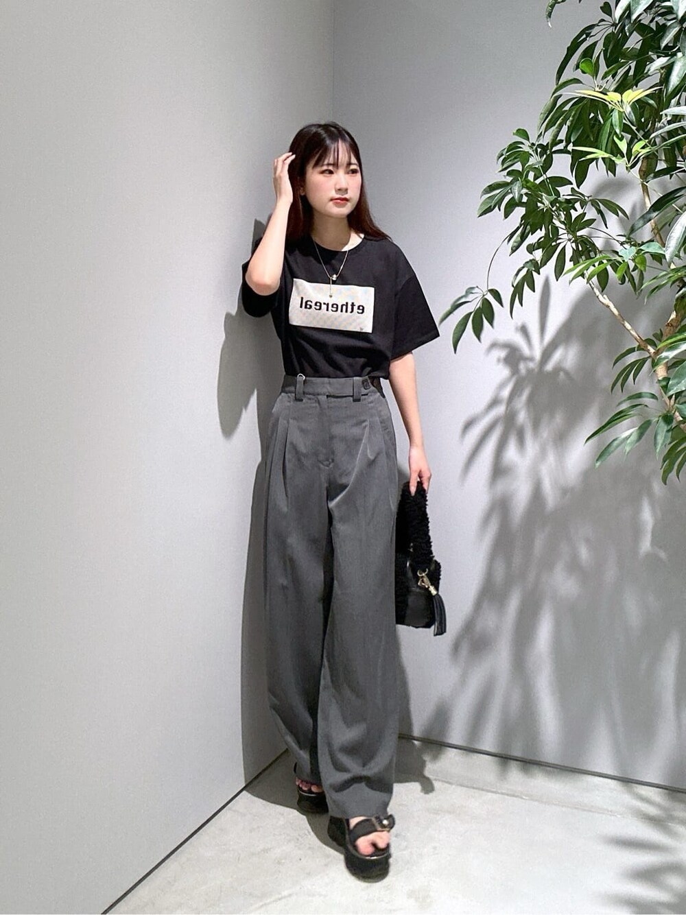 ブラック系のTシャツ/カットソー、グレー系のその他パンツ、ブラック系のハンドバッグを着用したレディースの夏コーディネートの3枚目の写真