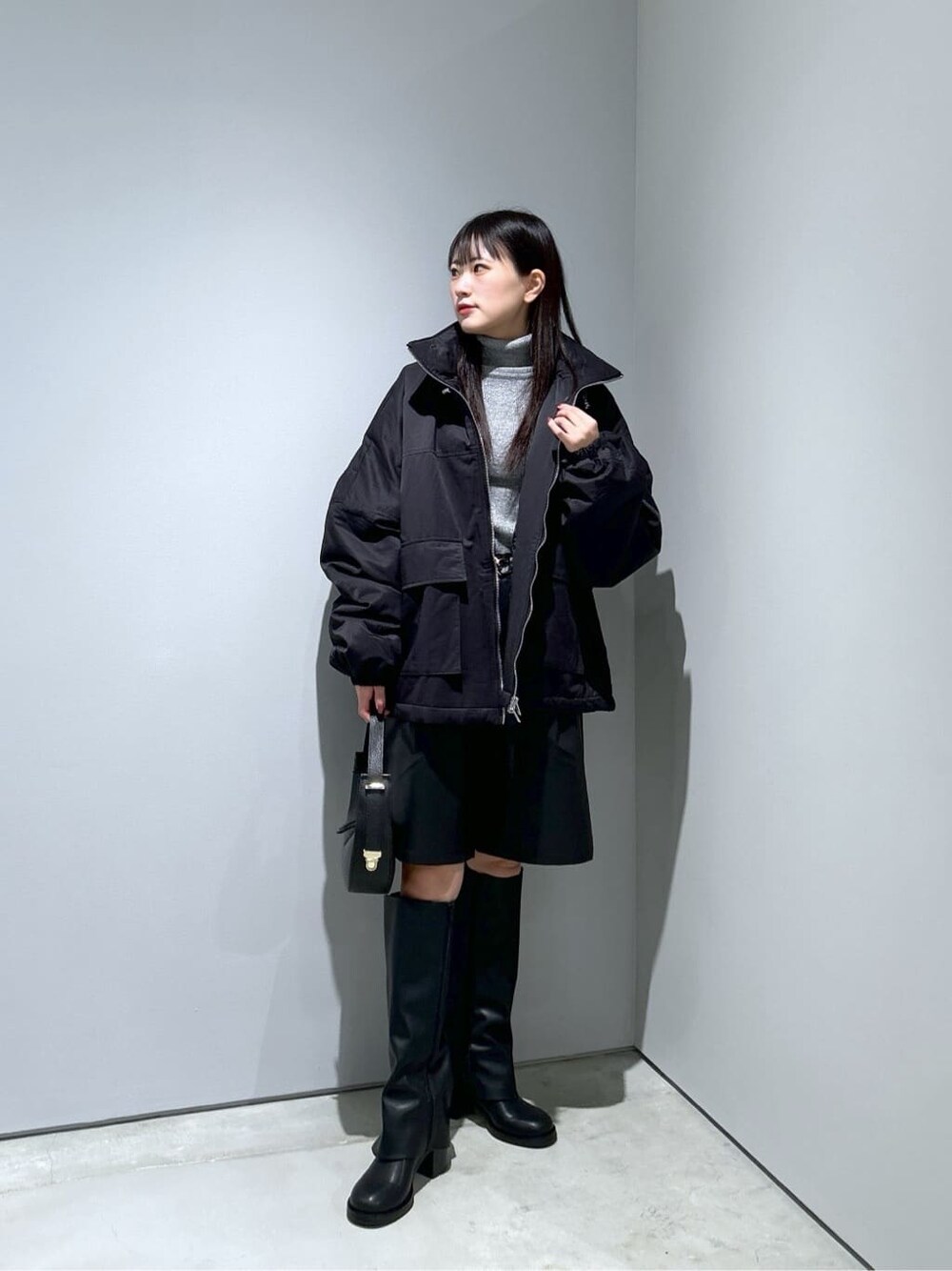 ブラック系のその他アウター、グレー系のニット/セーター、ブラック系のその他パンツを着用したレディースの冬コーディネートの2枚目の写真