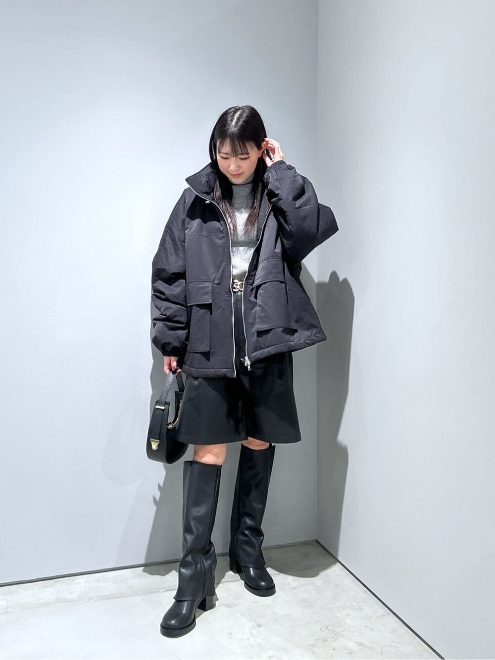 ブラック系のその他アウター、グレー系のニット/セーター、ブラック系のその他パンツを着用したレディースの冬コーディネートの4枚目の写真