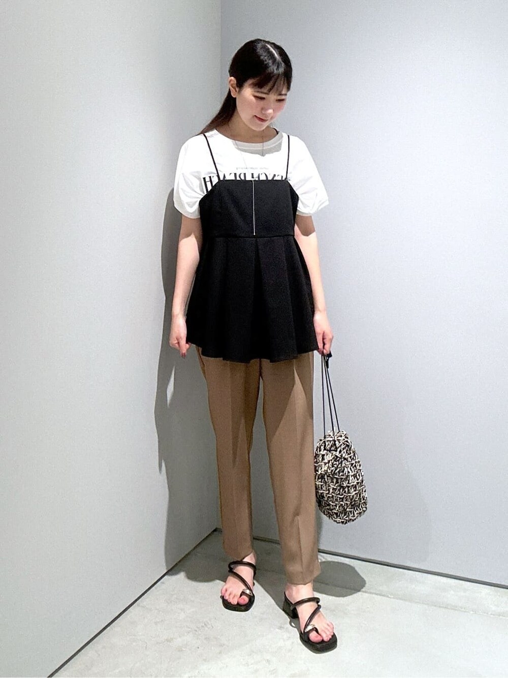 ブラック系のタンクトップ、イエロー系のその他パンツ、ブラック系のハンドバッグを着用したレディースの夏コーディネートの4枚目の写真