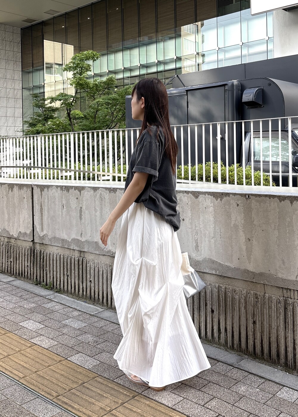 シルバー系のサンダル、グレー系のTシャツ/カットソー、シルバー系のトートバッグを着用したレディースの春コーディネートの4枚目の写真