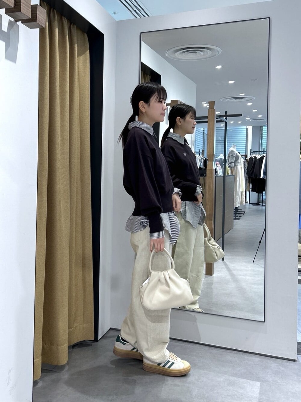 ブラック系のニット/セーター、ブラック系のシャツ/ブラウス、ホワイト系のその他パンツを着用したレディースの春コーディネートの5枚目の写真