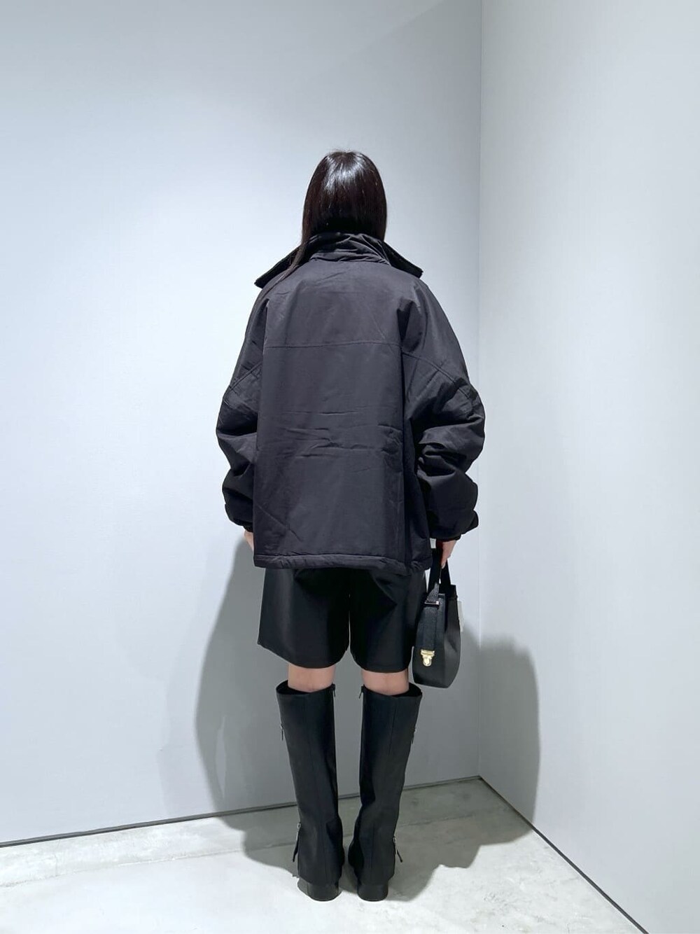 ブラック系のその他アウター、グレー系のニット/セーター、ブラック系のその他パンツを着用したレディースの冬コーディネートの5枚目の写真