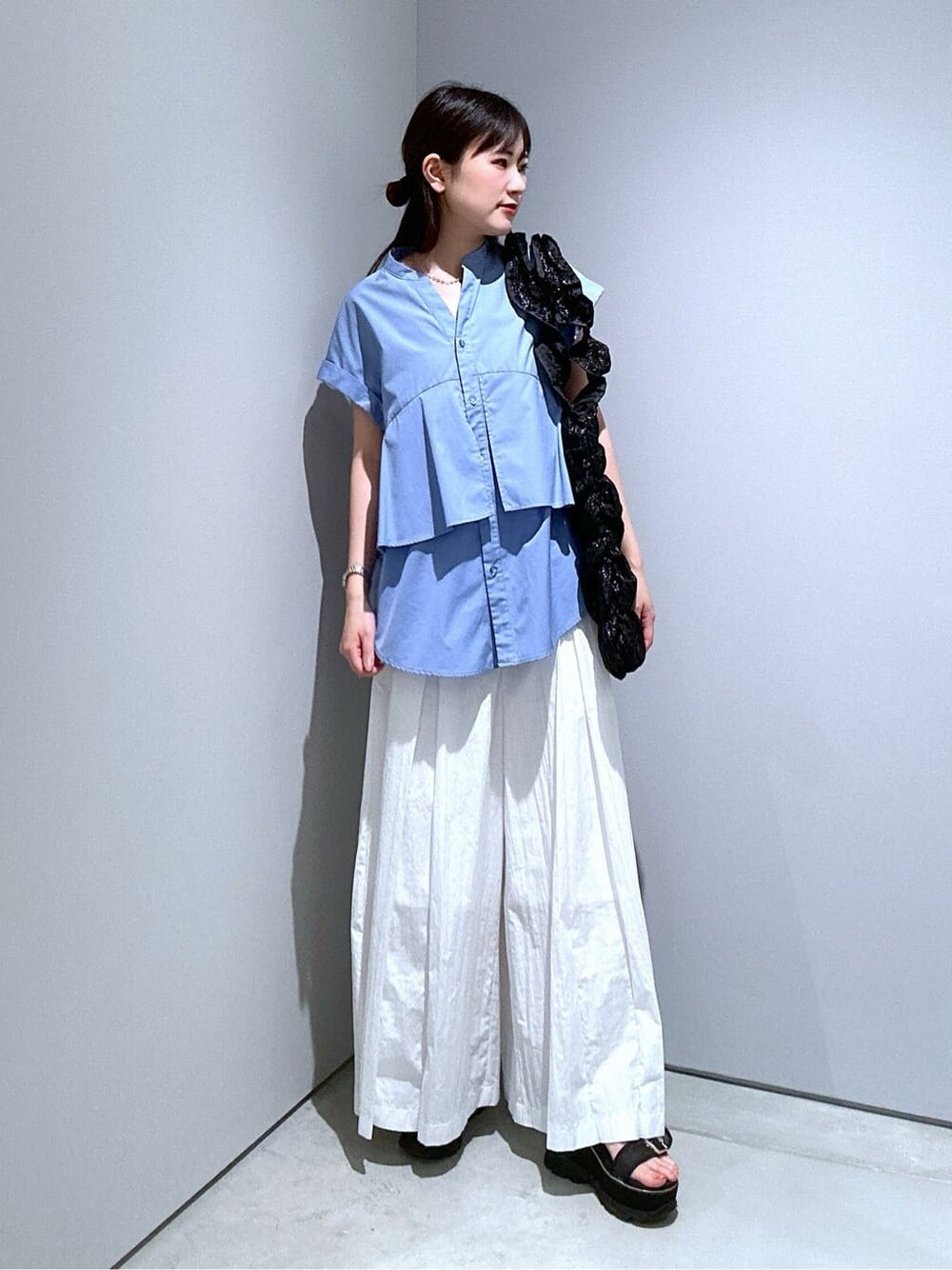 ブルー系のシャツ/ブラウス、ホワイト系のその他パンツ、ブラック系のトートバッグを着用したレディースの夏コーディネートの5枚目の写真