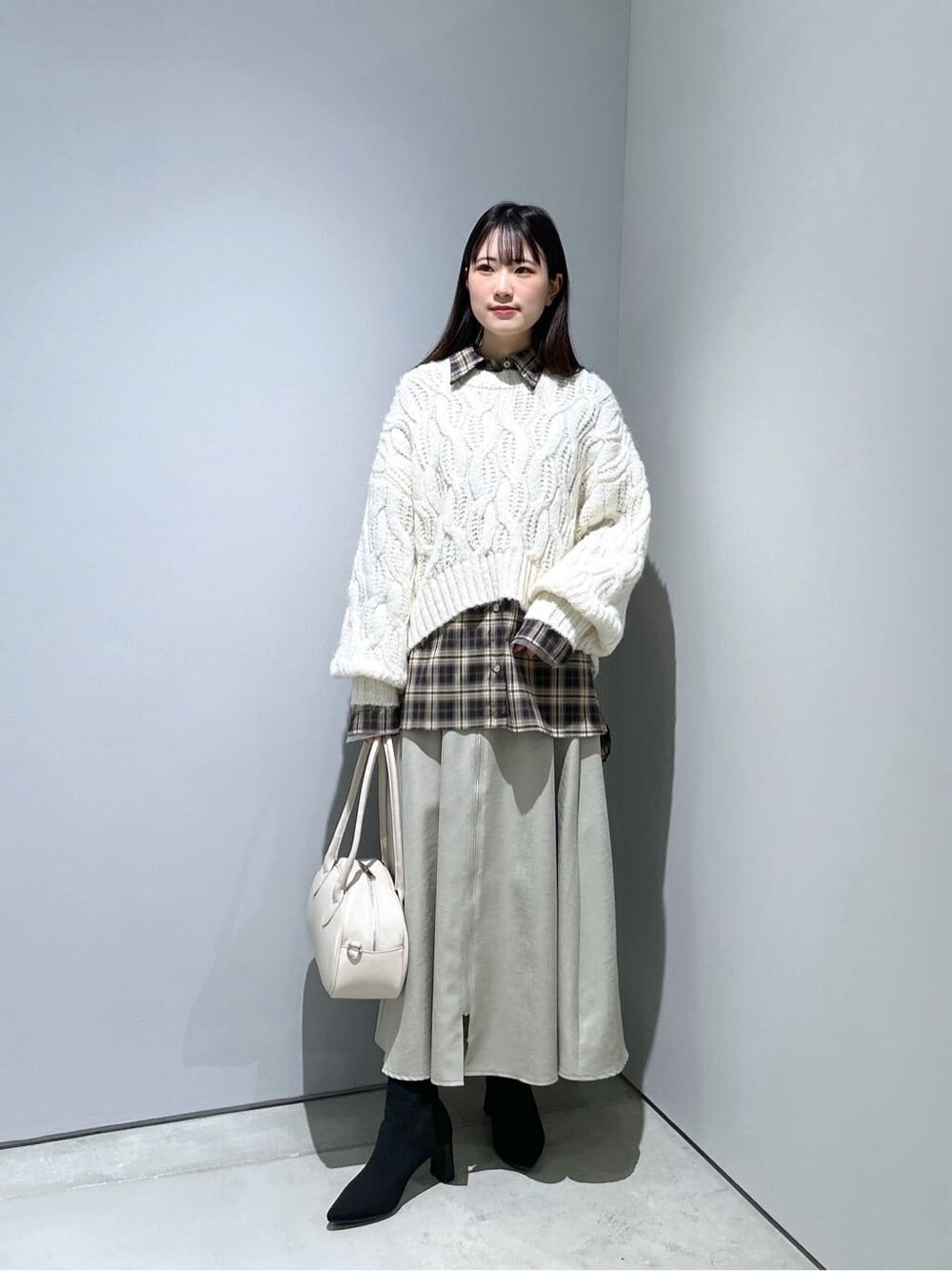 ホワイト系のニット/セーター、ベージュ系のシャツ/ブラウス、グリーン系のスカートを着用したレディースの冬コーディネートの3枚目の写真