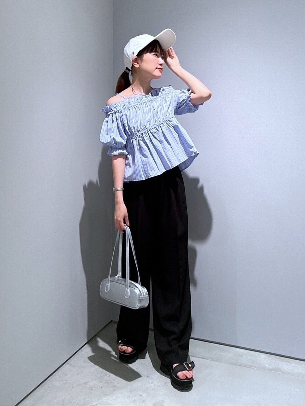 ブルー系のシャツ/ブラウス、ブラック系のその他パンツ、シルバー系のハンドバッグを着用したレディースの夏コーディネートの5枚目の写真