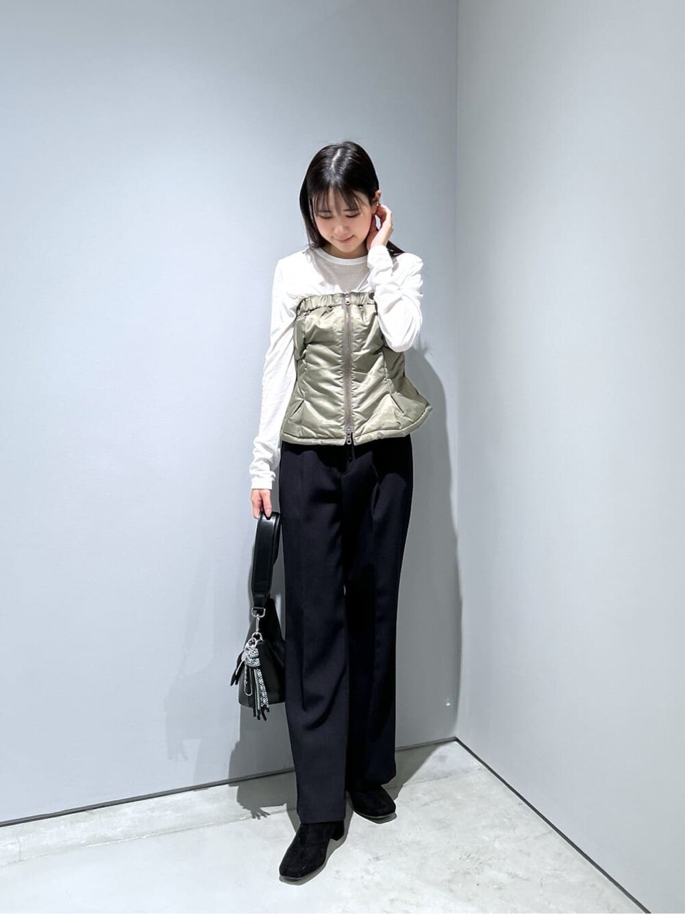 グリーン系のその他アウター、ホワイト系のTシャツ/カットソー、ブラック系のその他パンツを着用したレディースの冬コーディネートの4枚目の写真