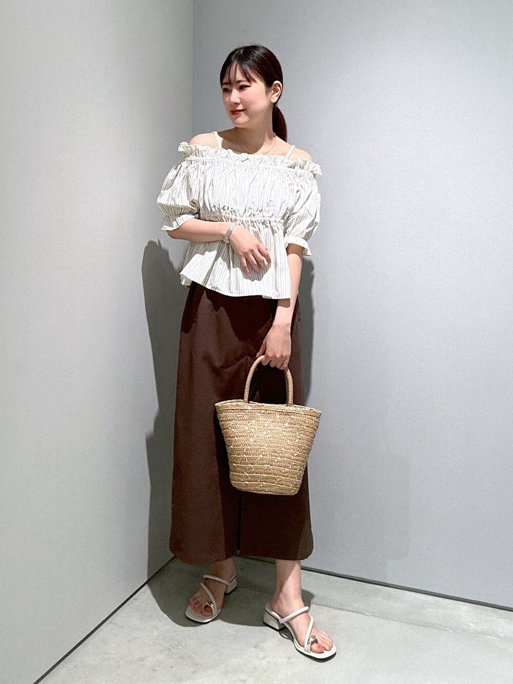 ベージュ系のシャツ/ブラウス、ブラウン系のスカート、ホワイト系のサンダルを着用したレディースの夏コーディネートの2枚目の写真