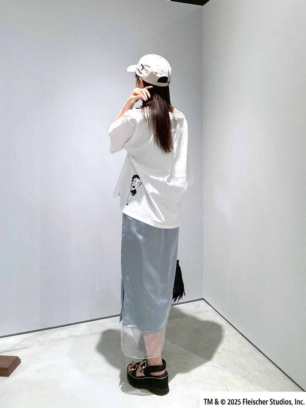 ホワイト系のTシャツ/カットソー、ブルー系のスカート、ブラック系のハンドバッグを着用したレディースの夏コーディネートの2枚目の写真