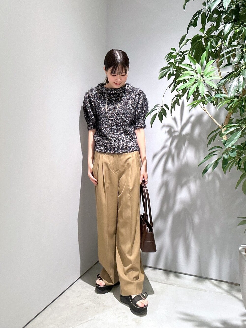 ブラック系のニット/セーター、イエロー系のその他パンツ、ブラウン系のショルダーバッグを着用したレディースの秋コーディネートの4枚目の写真