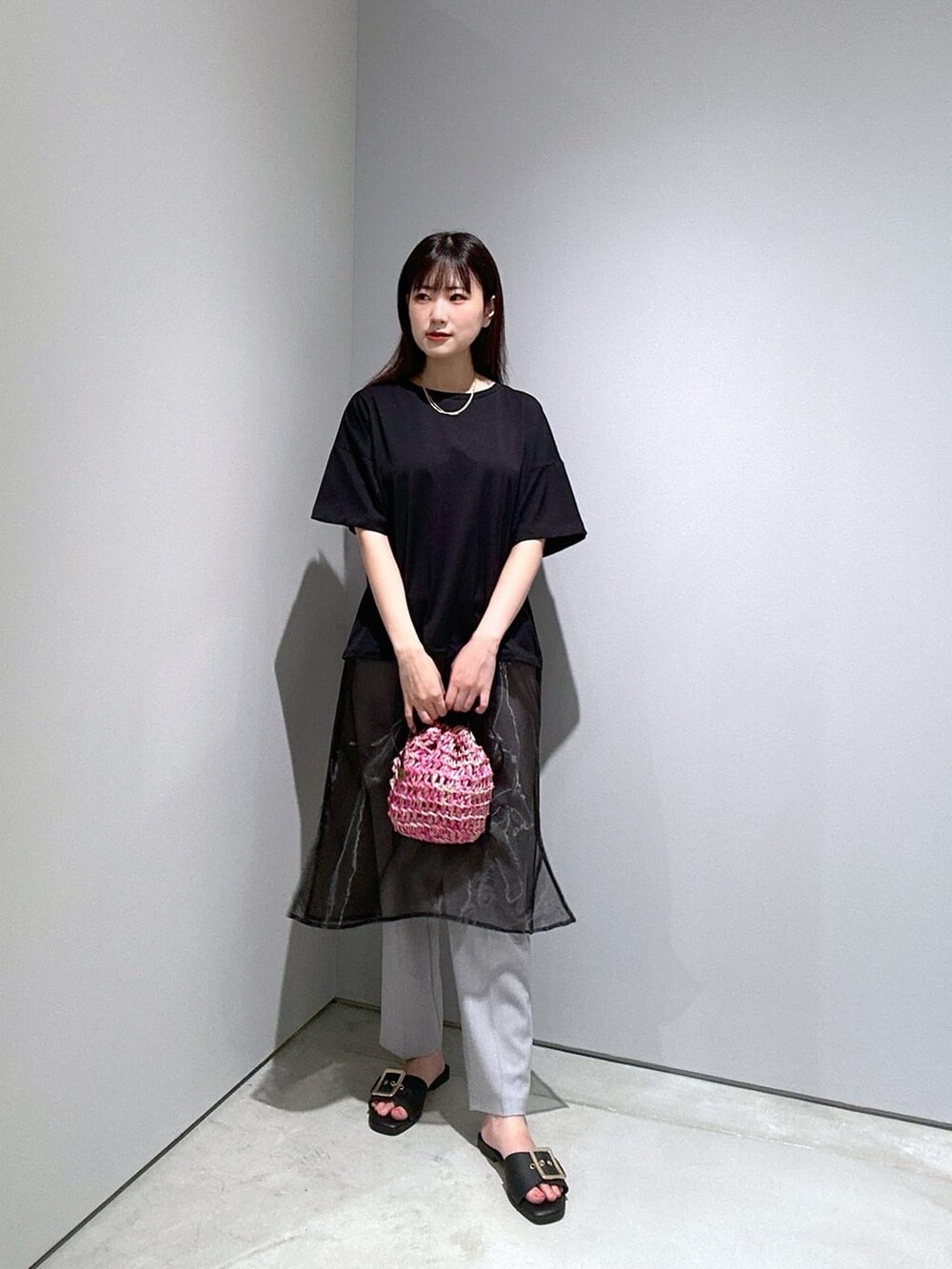 ブラック系のTシャツ/カットソー、グレー系のその他パンツ、ピンク系のハンドバッグを着用したレディースの夏コーディネートの3枚目の写真