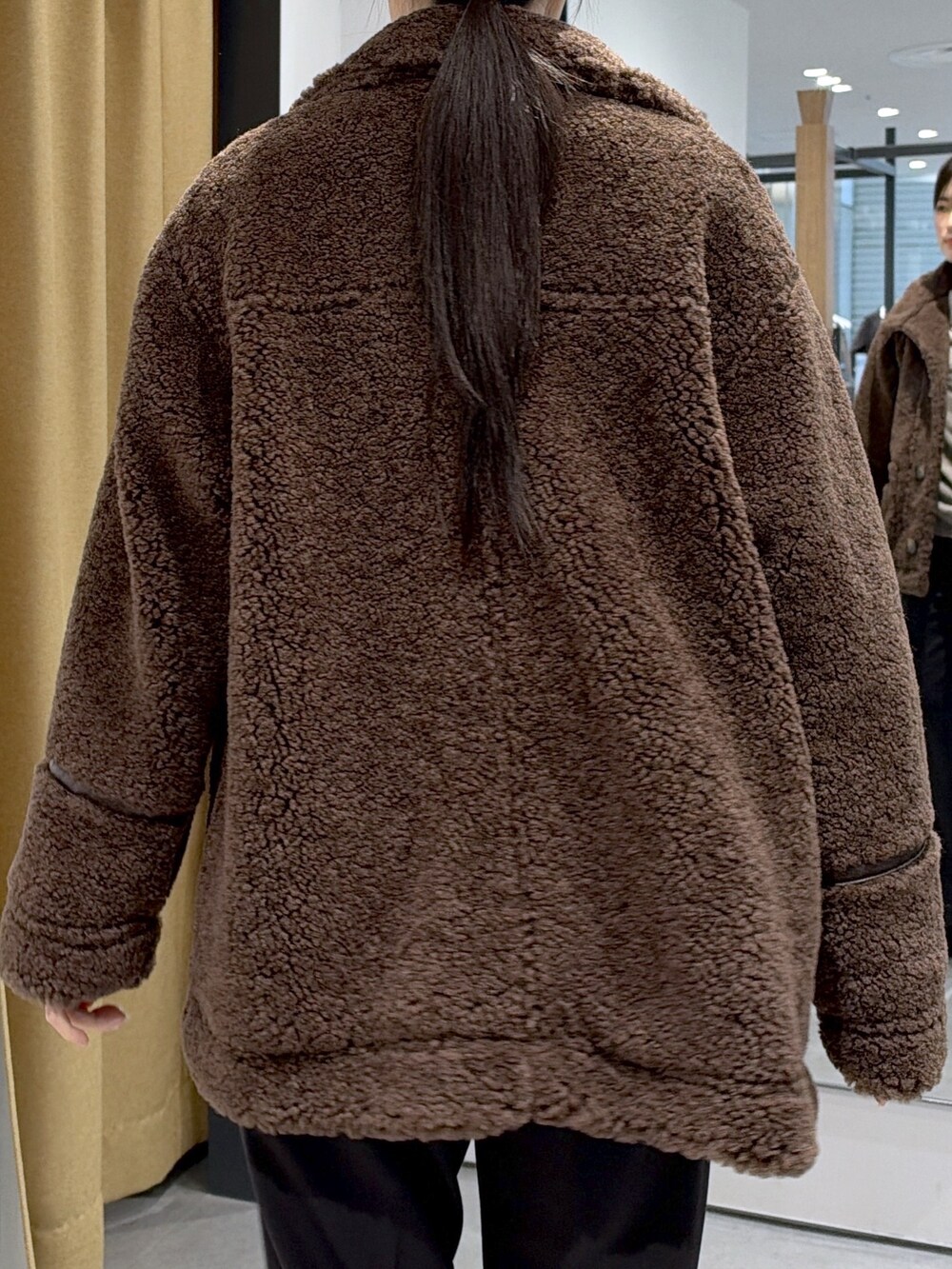 ブラウン系のブルゾン、ブラウン系のTシャツ/カットソー、ブラック系のその他パンツを着用したレディースの秋コーディネートの9枚目の写真
