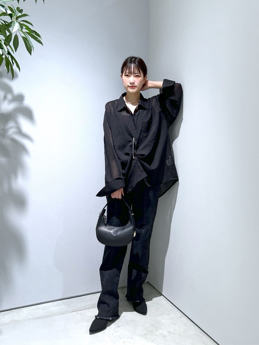 ブラック系のシャツ/ブラウス、グレー系のデニムパンツ、ブラック系のショルダーバッグを着用したレディースの秋コーディネートの2枚目の写真