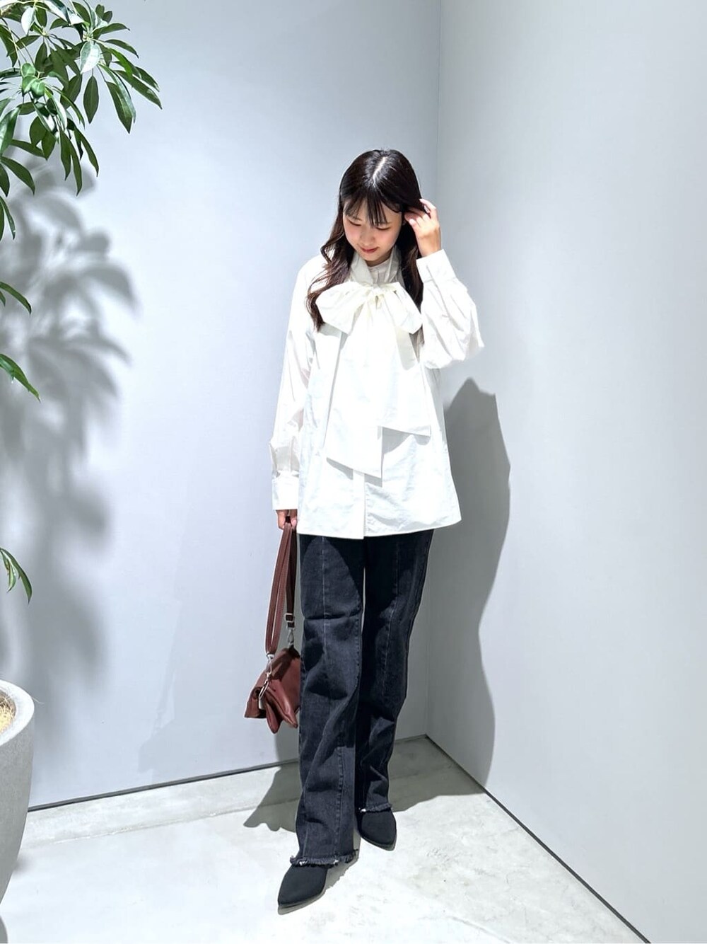 ホワイト系のシャツ/ブラウス、グレー系のデニムパンツ、ブラウン系のショルダーバッグを着用したレディースの秋コーディネートの5枚目の写真