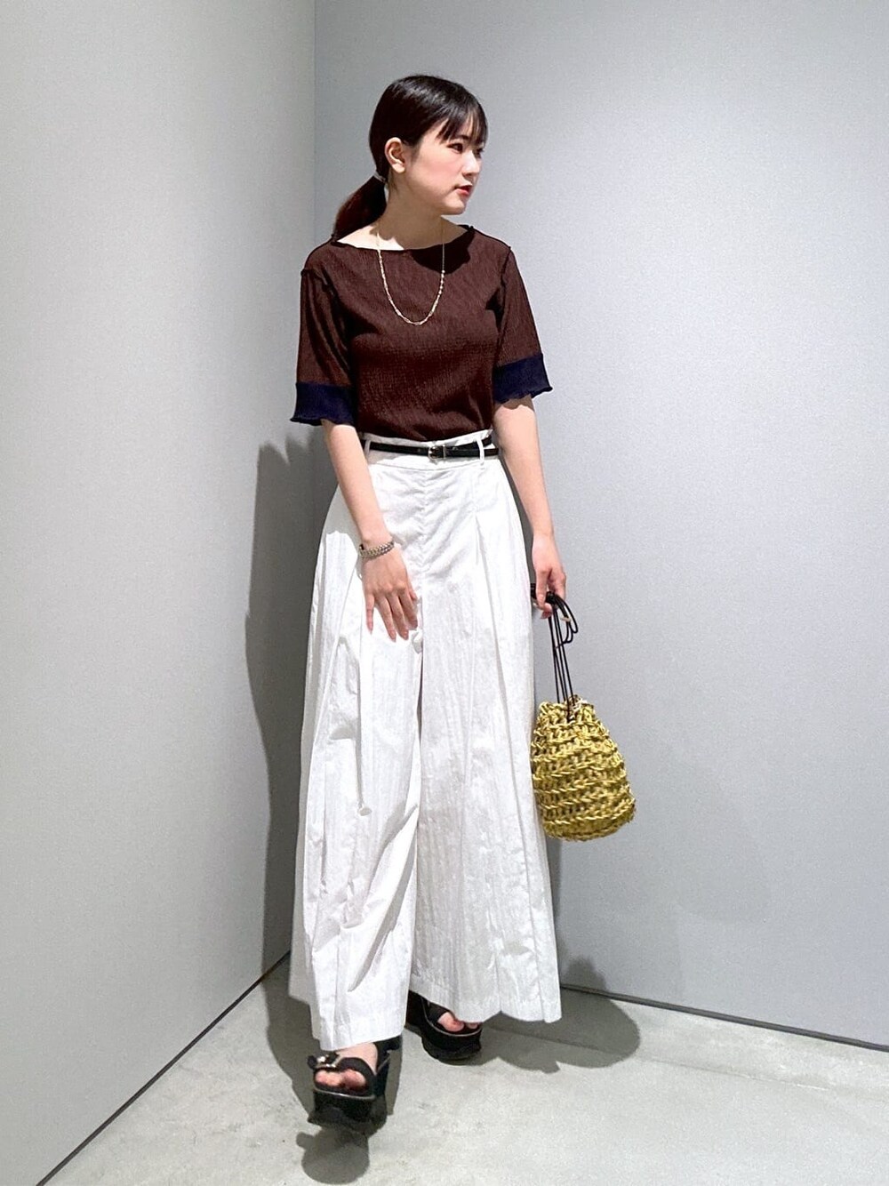 ブラウン系のTシャツ/カットソー、ホワイト系のその他パンツ、イエロー系のハンドバッグを着用したレディースの夏コーディネートの3枚目の写真