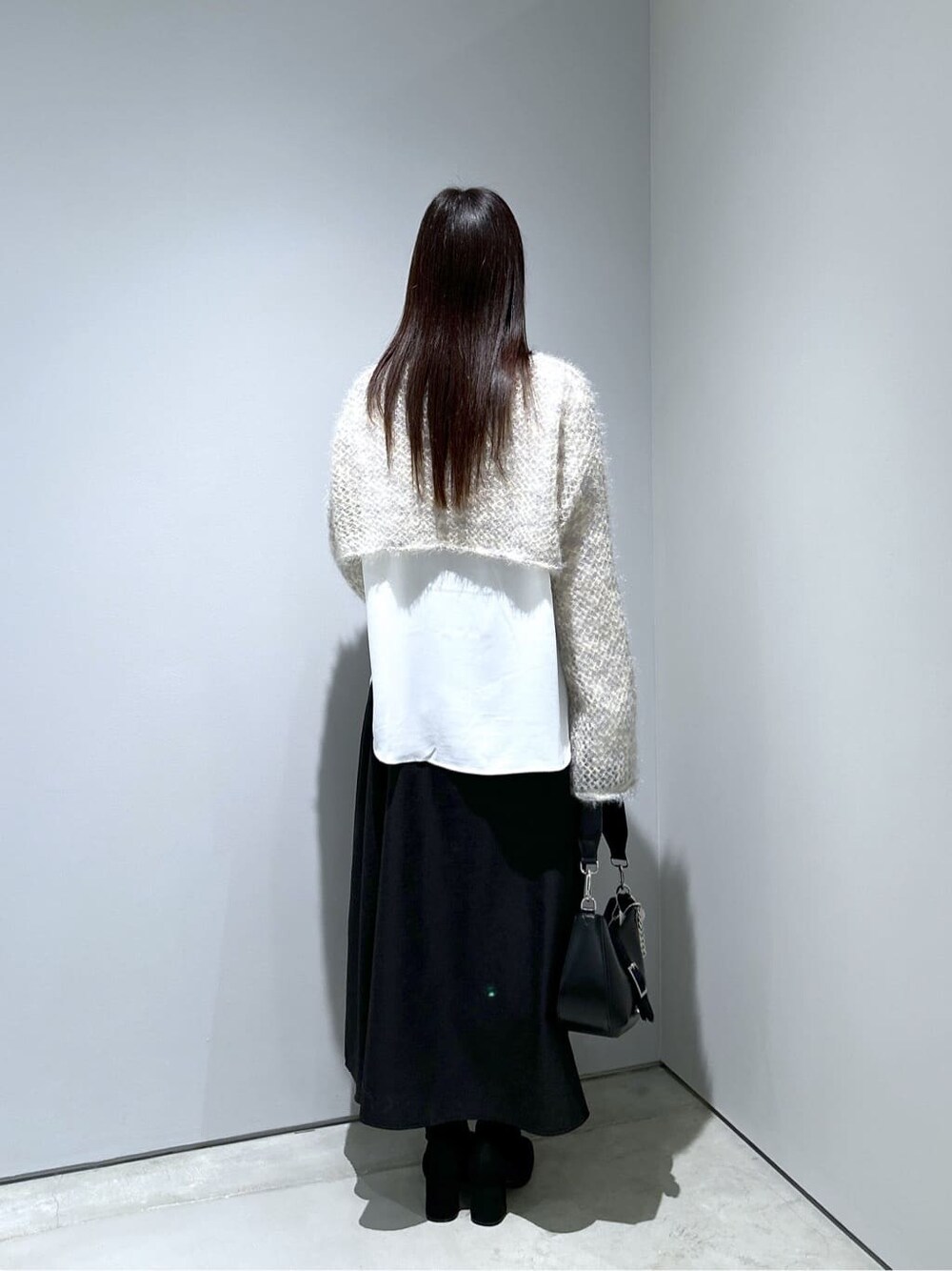 ベージュ系のニット/セーター、ホワイト系のシャツ/ブラウス、ブラック系のスカートを着用したレディースの冬コーディネートの5枚目の写真