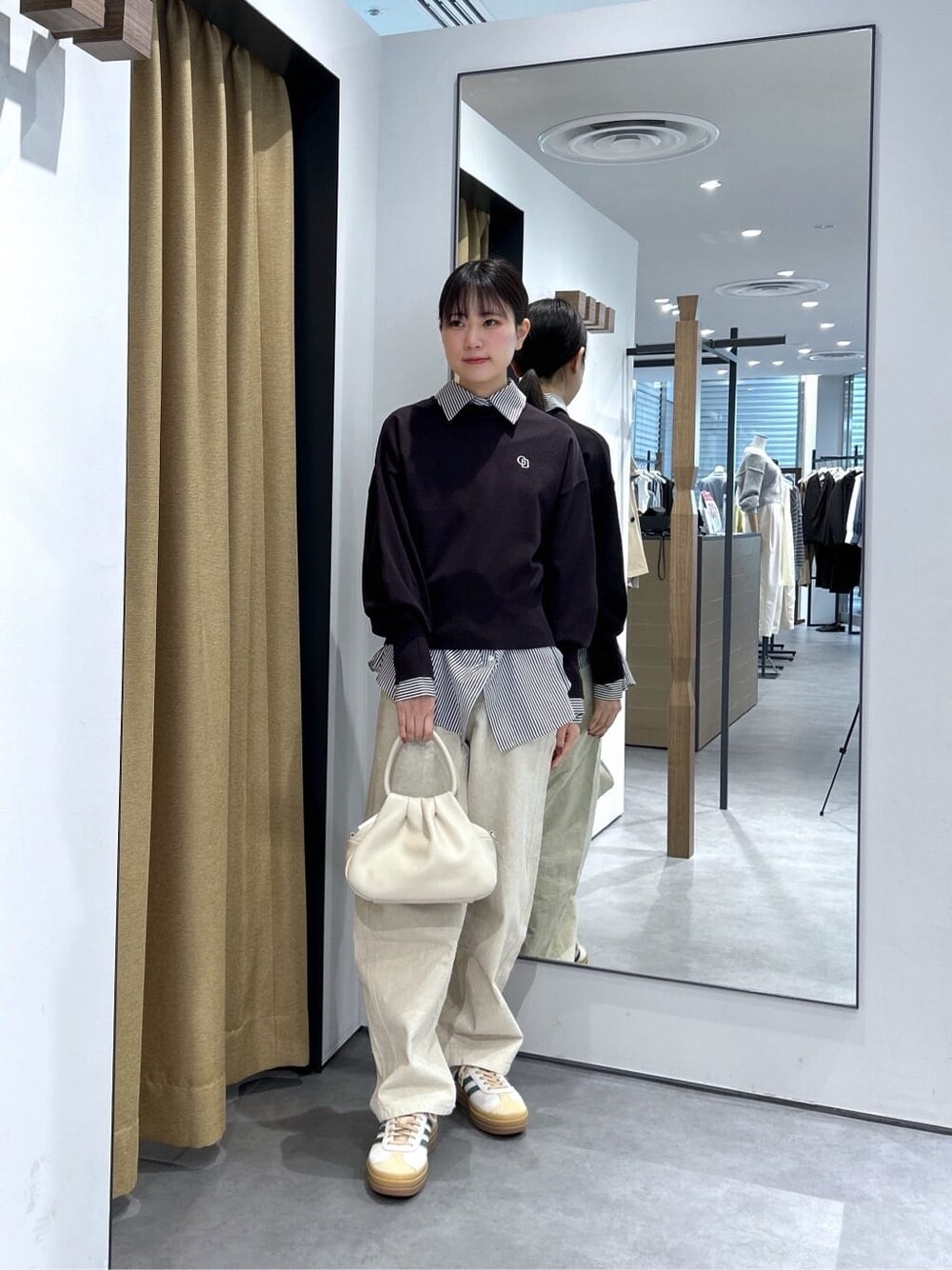 ブラック系のニット/セーター、ブラック系のシャツ/ブラウス、ホワイト系のその他パンツを着用したレディースの春コーディネートの3枚目の写真