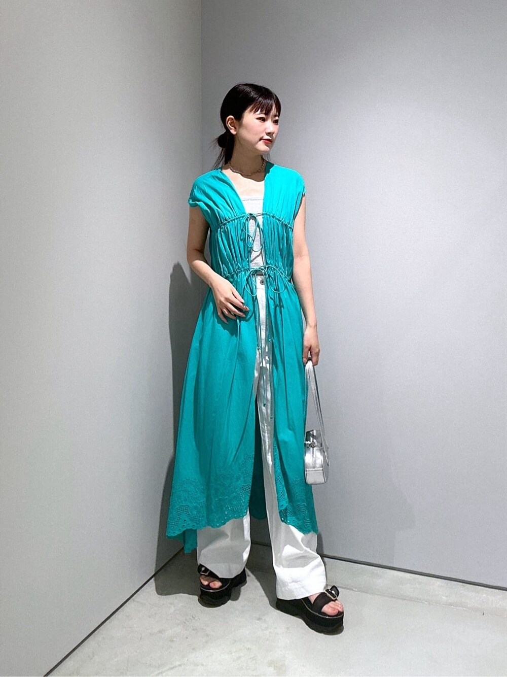 ブルー系のワンピース、ホワイト系のタンクトップ、ホワイト系のデニムパンツを着用したレディースの夏コーディネートの3枚目の写真
