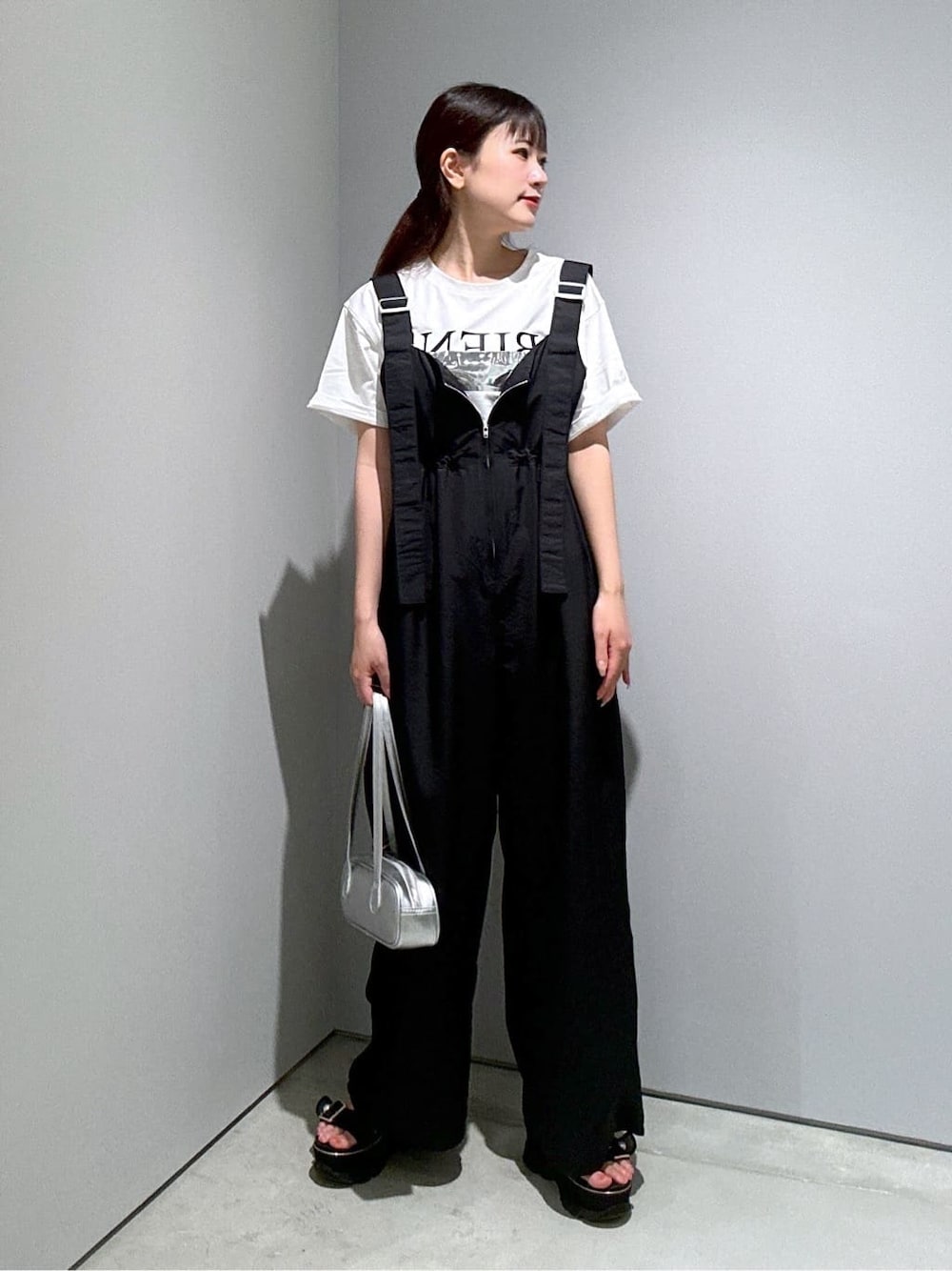 ホワイト系のTシャツ/カットソー、ブラック系のサロペット/オーバーオール、シルバー系のハンドバッグを着用したレディースの夏コーディネートの4枚目の写真