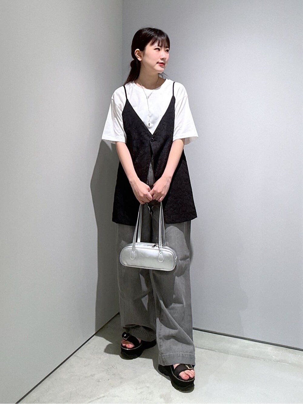 ホワイト系のTシャツ/カットソー、ブラック系のベスト、グレー系のデニムパンツを着用したレディースの夏コーディネートの3枚目の写真