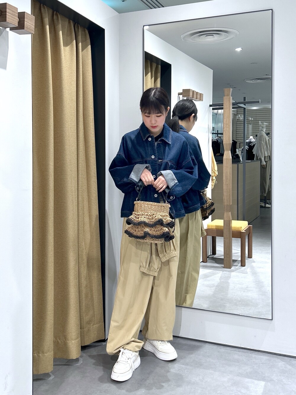 ブルー系のデニムジャケット、ホワイト系のニット/セーター、ベージュ系のその他パンツを着用したレディースの春コーディネートの3枚目の写真