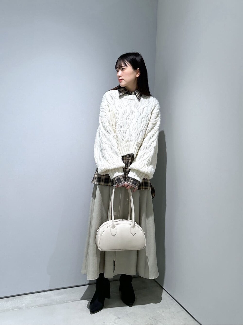ホワイト系のニット/セーター、ベージュ系のシャツ/ブラウス、グリーン系のスカートを着用したレディースの冬コーディネートの2枚目の写真