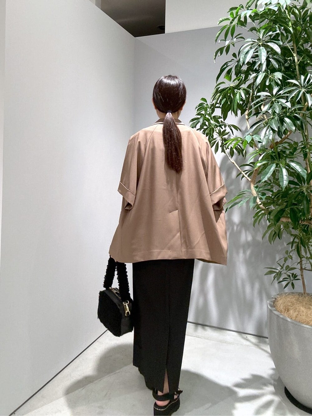 イエロー系のテーラードジャケット、ホワイト系のTシャツ/カットソー、ブラック系のスカートを着用したレディースの夏コーディネートの6枚目の写真