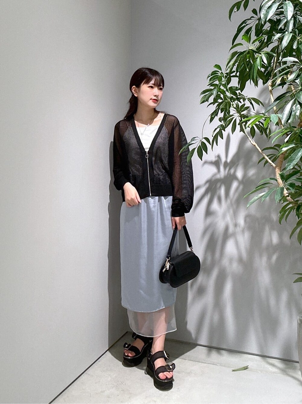 ブラック系のカーディガン/ボレロ、ホワイト系のタンクトップ、ブルー系のスカートを着用したレディースの夏コーディネートの3枚目の写真