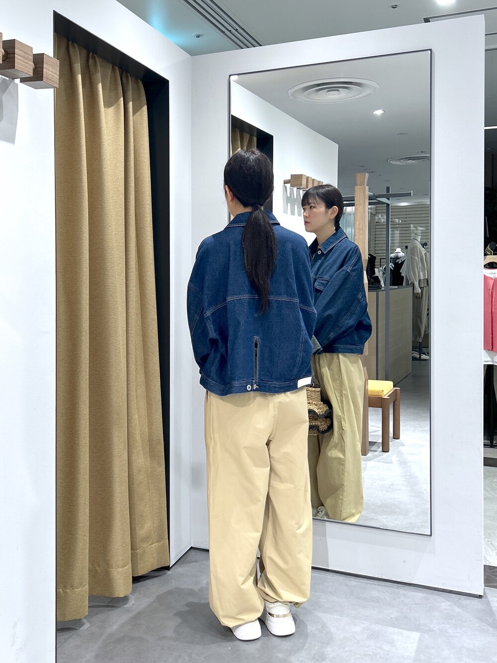 ブルー系のデニムジャケット、ホワイト系のニット/セーター、ベージュ系のその他パンツを着用したレディースの春コーディネートの6枚目の写真
