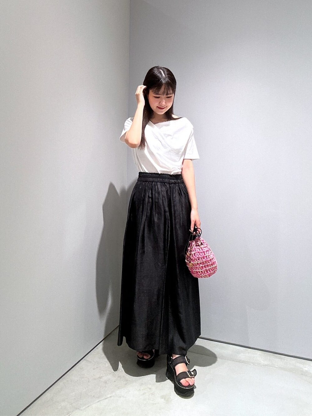 ホワイト系のTシャツ/カットソー、ブラック系のスカート、ピンク系のハンドバッグを着用したレディースの夏コーディネートの4枚目の写真