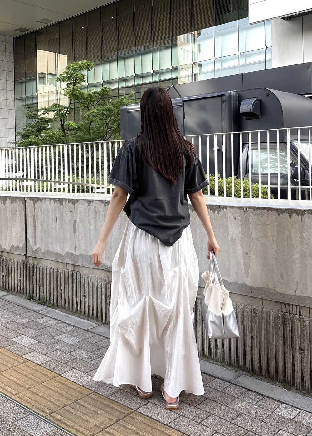 シルバー系のサンダル、グレー系のTシャツ/カットソー、シルバー系のトートバッグを着用したレディースの春コーディネートの5枚目の写真