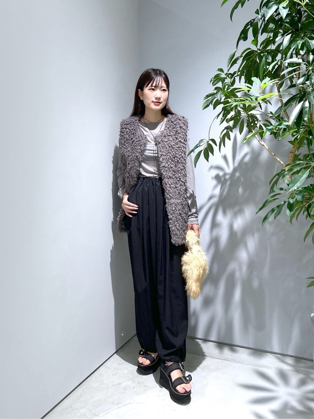 グレー系のTシャツ/カットソー、ブラック系のその他パンツ、ベージュ系のハンドバッグを着用したレディースの秋コーディネートの3枚目の写真