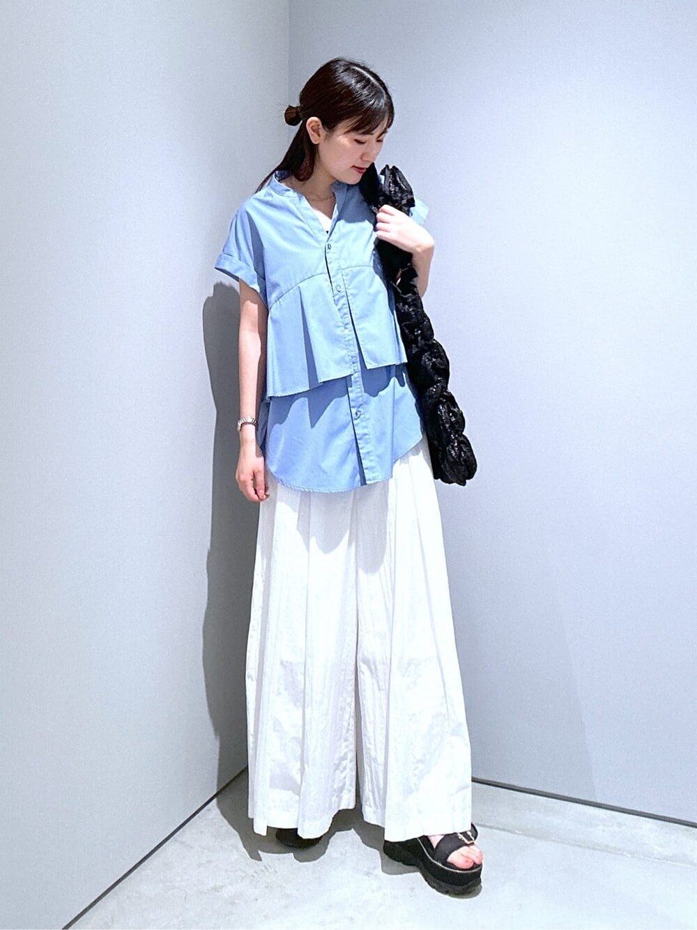 ブルー系のシャツ/ブラウス、ホワイト系のその他パンツ、ブラック系のトートバッグを着用したレディースの夏コーディネートの6枚目の写真