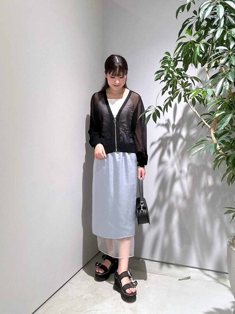 ブラック系のカーディガン/ボレロ、ホワイト系のタンクトップ、ブルー系のスカートを着用したレディースの夏コーディネートの4枚目の写真