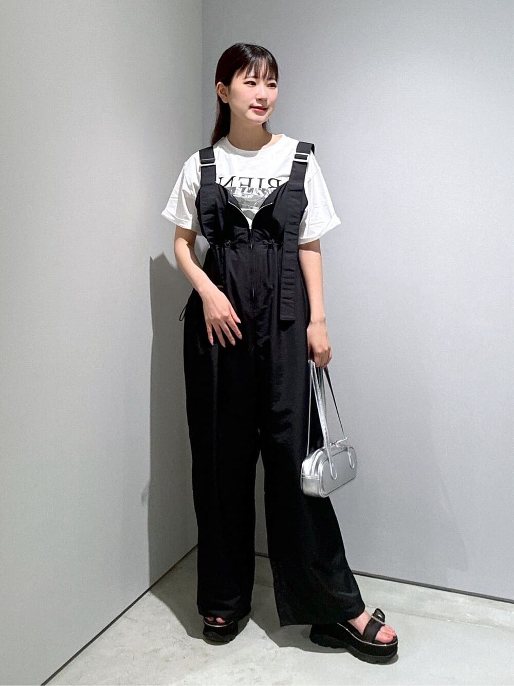 ホワイト系のTシャツ/カットソー、ブラック系のサロペット/オーバーオール、シルバー系のハンドバッグを着用したレディースの夏コーディネートの3枚目の写真