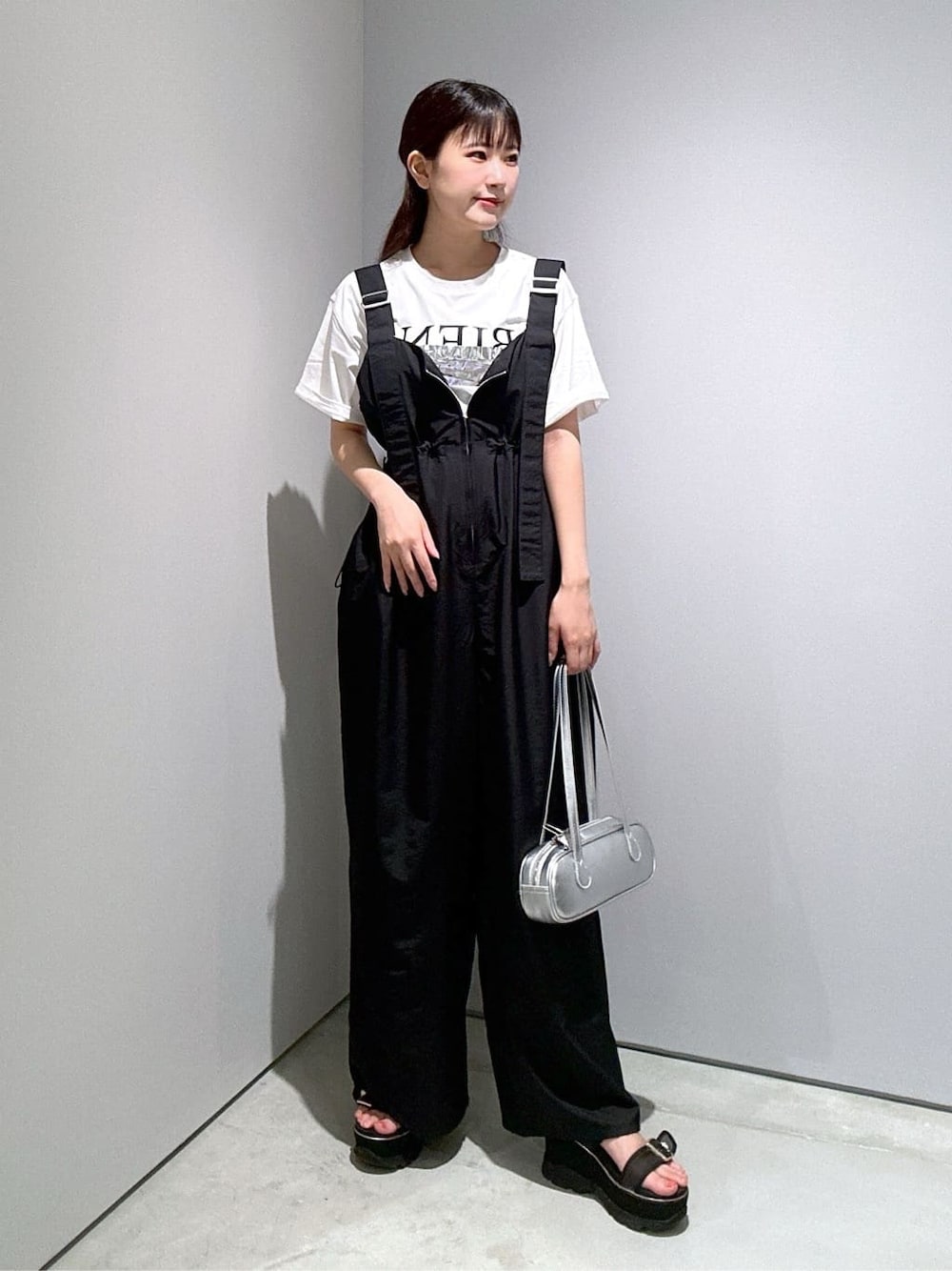 ホワイト系のTシャツ/カットソー、ブラック系のサロペット/オーバーオール、シルバー系のハンドバッグを着用したレディースの夏コーディネートの2枚目の写真