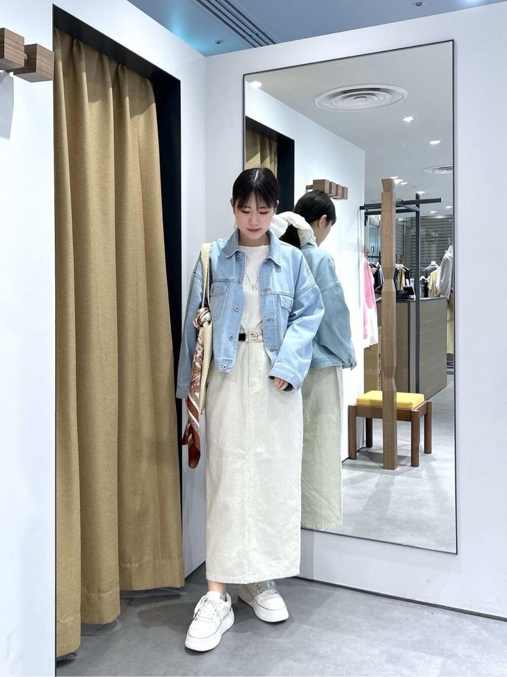 ブルー系のデニムジャケット、ホワイト系のTシャツ/カットソー、ホワイト系のスカートを着用したレディースの春コーディネートの3枚目の写真