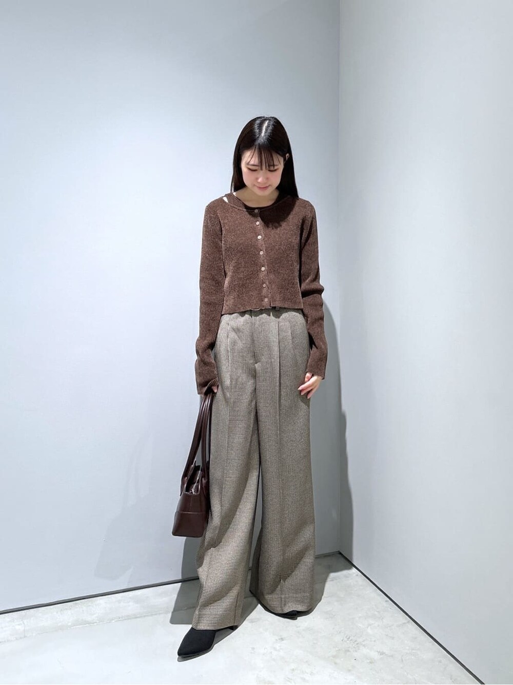 ホワイト系のチェスターコート、ブラウン系のニット/セーター、ベージュ系のその他パンツを着用したレディースの秋コーディネートの4枚目の写真